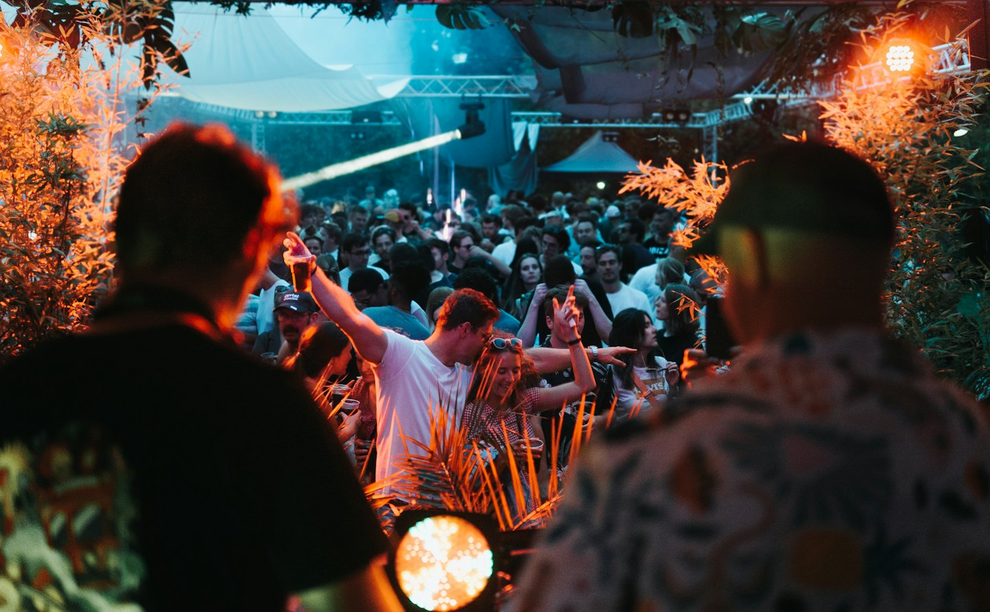 People dancing and socializing at an outdoor evening event.